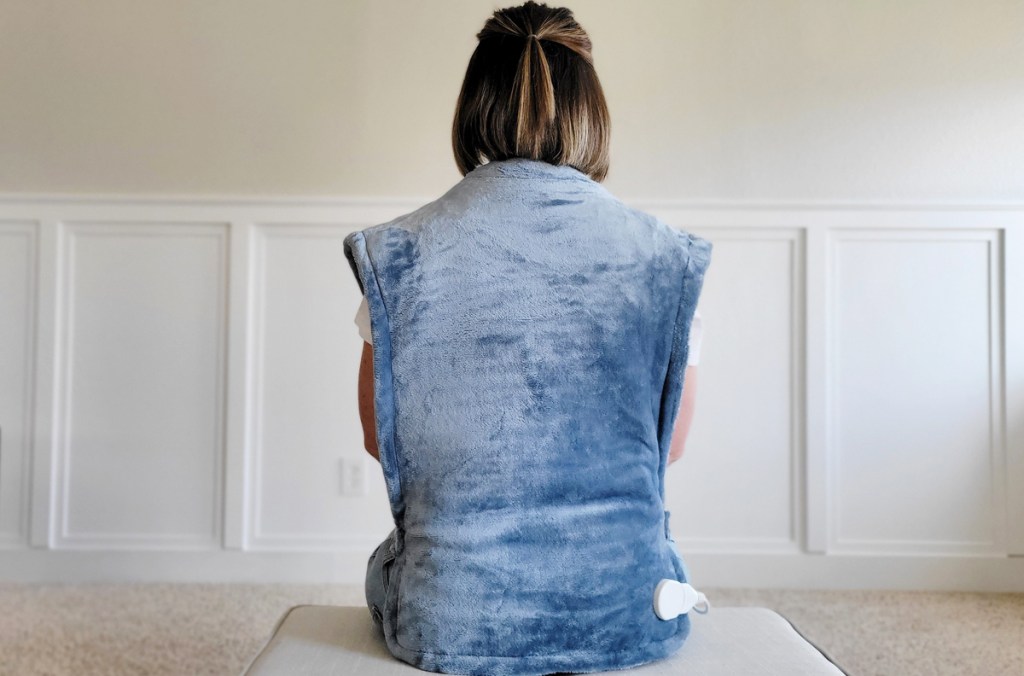 woman wearing blue heating pad around her back