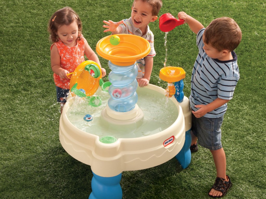 Toddlers playing around a water table