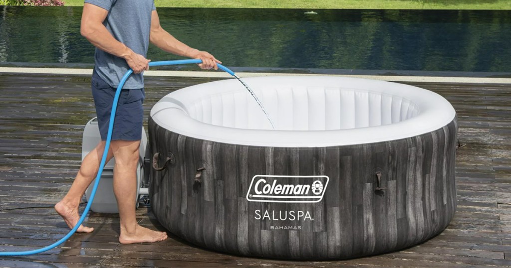 coleman inflatable hot tub with man filling it with water