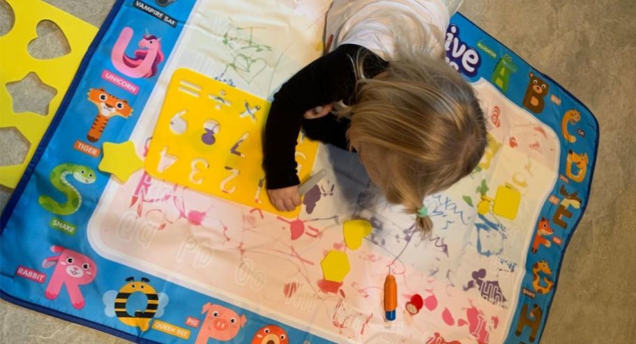 Child playing with a water mat on the floor