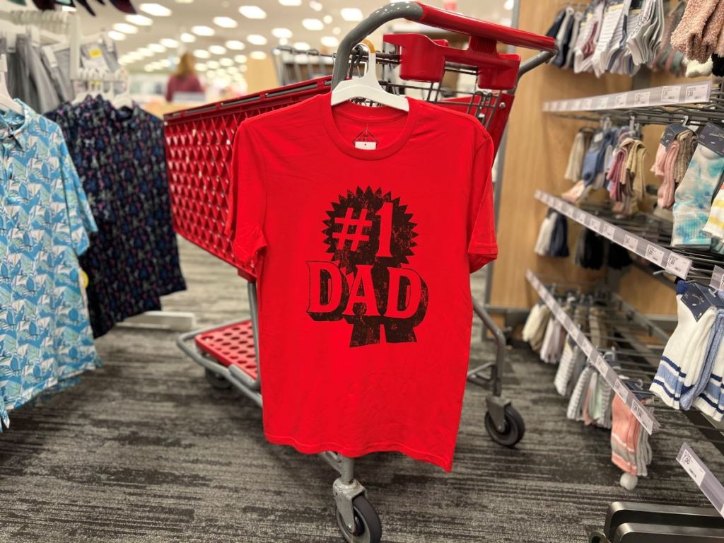 Red shirt that says #1 dad hanging on a cart