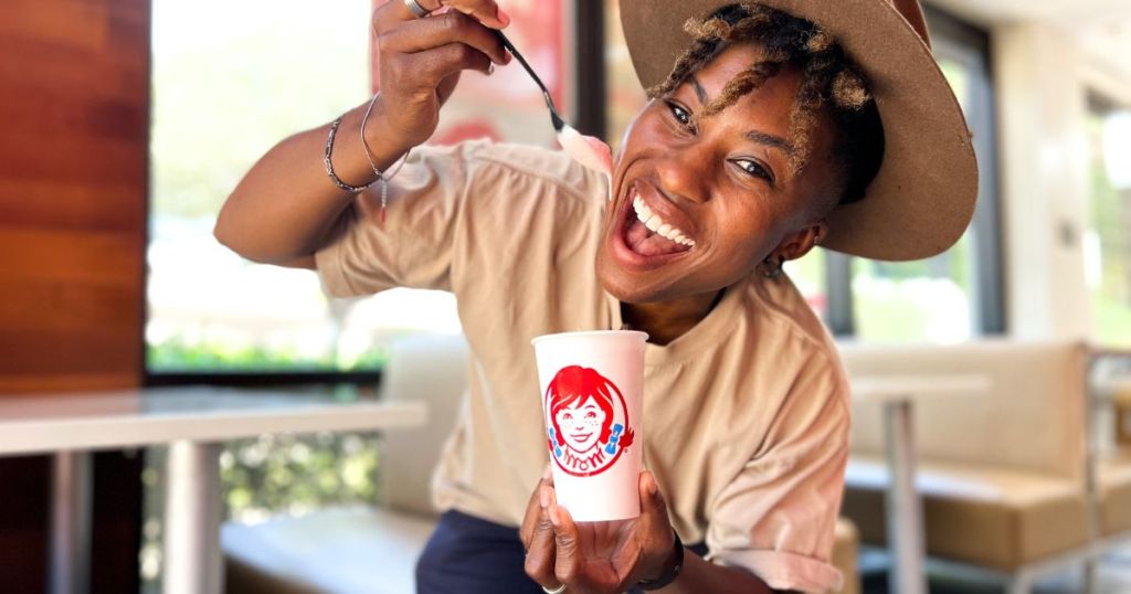 woman eating a Wendy's Strawberry Frosty