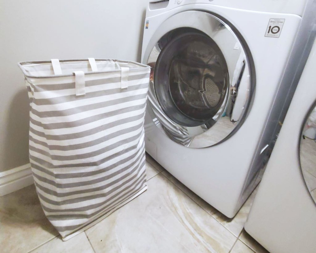 striped laundry hampernext to washing machine