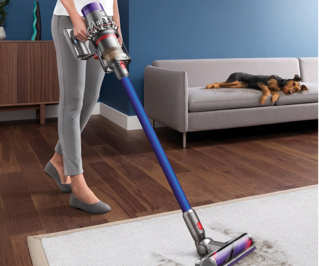 Woman cleaning rug in living room with Dyson 10