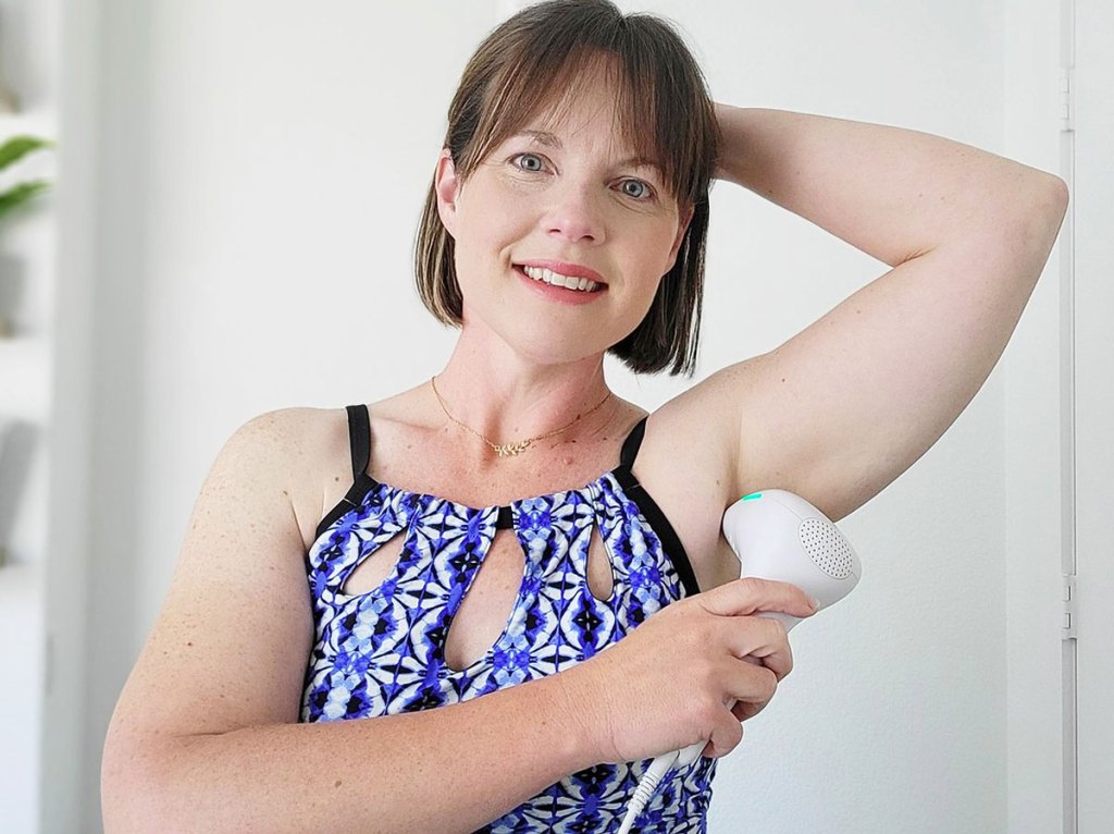 woman using laser hair remover in armpit