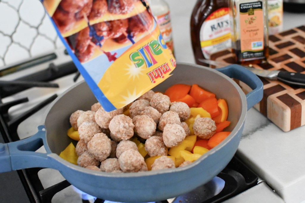 adding frozen meatballs to skillet with bell peppers