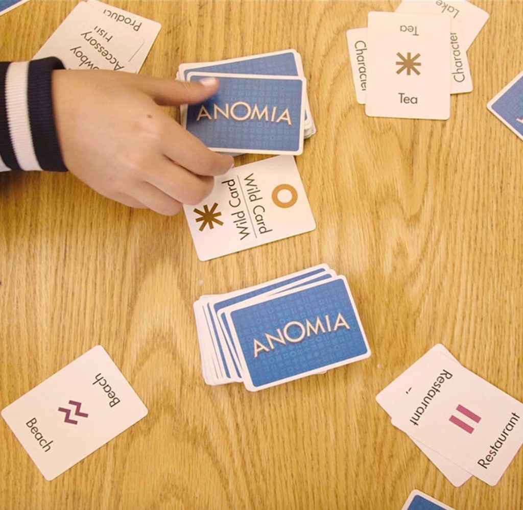 hand picking up anomia card from deck on table