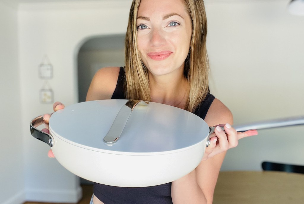 woman holding white caraway saute pan