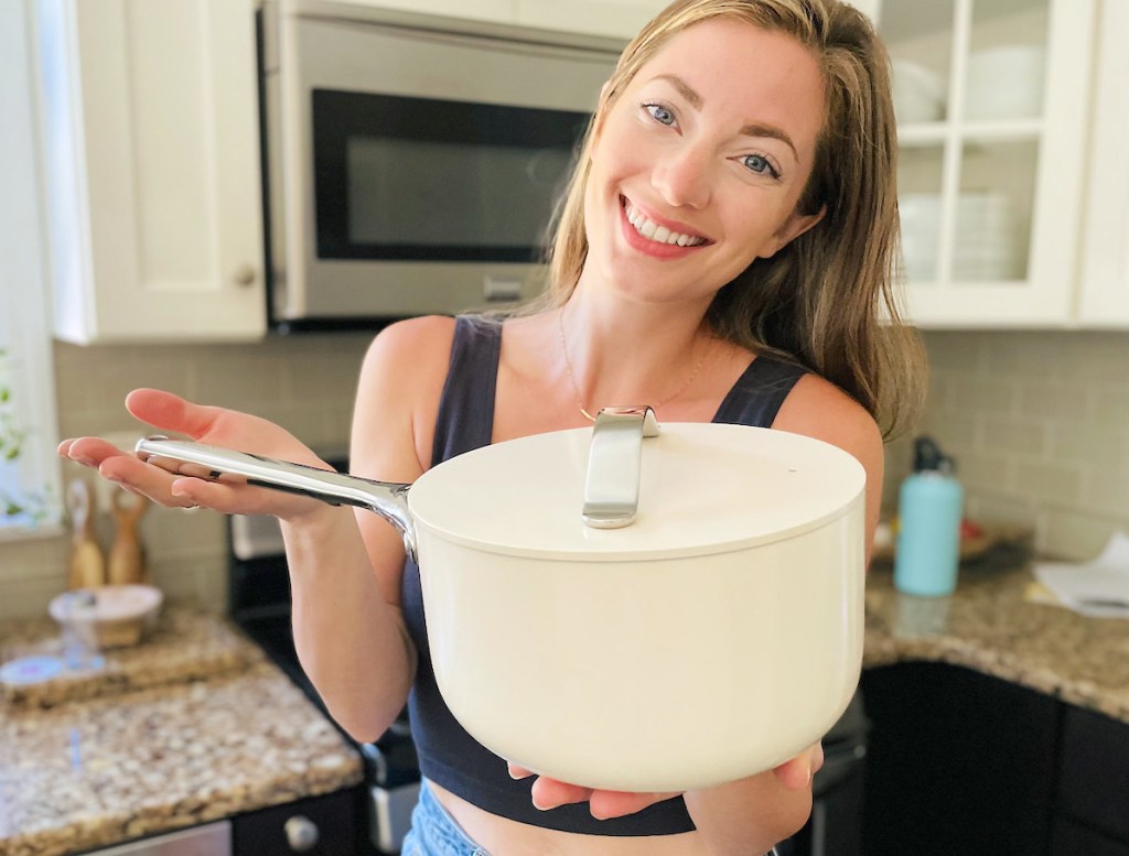 woman holding up white sauce pot