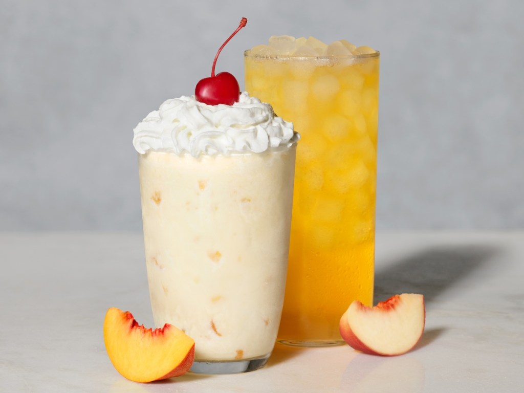 Peach milkshake and iced drink next to peach slices