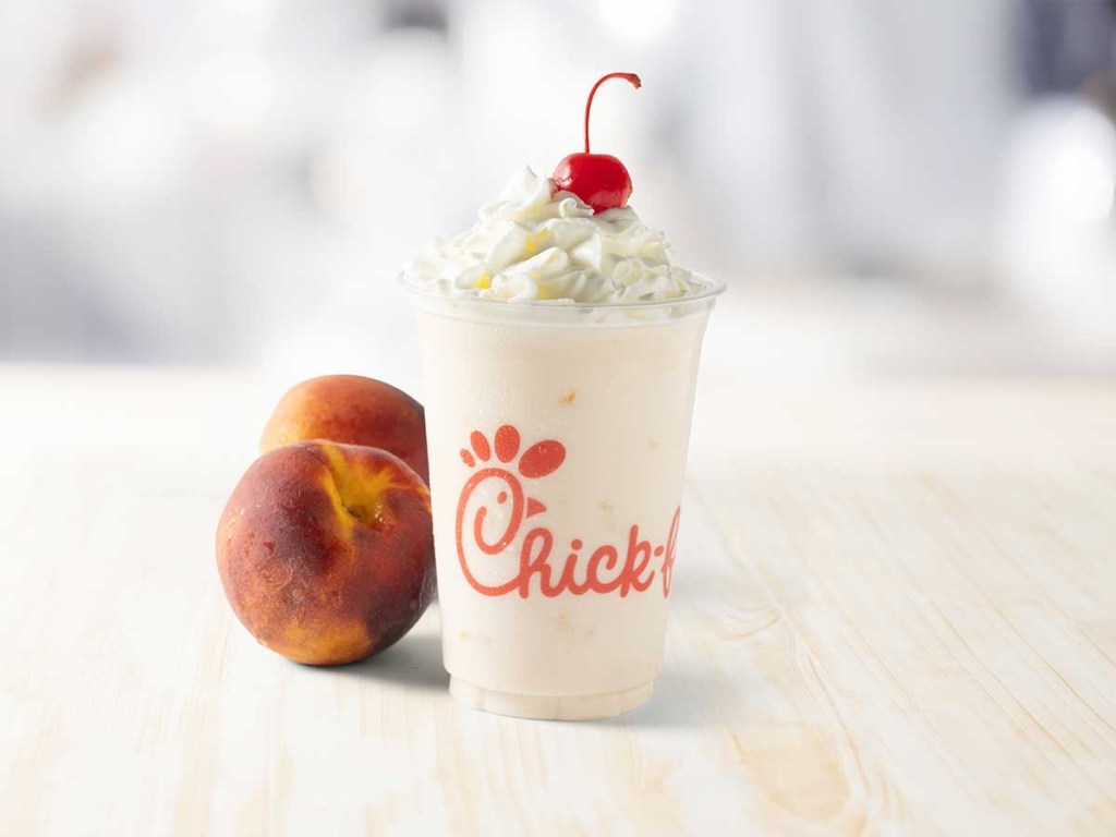 Chick-fil-A-peach milkshake next to peaches