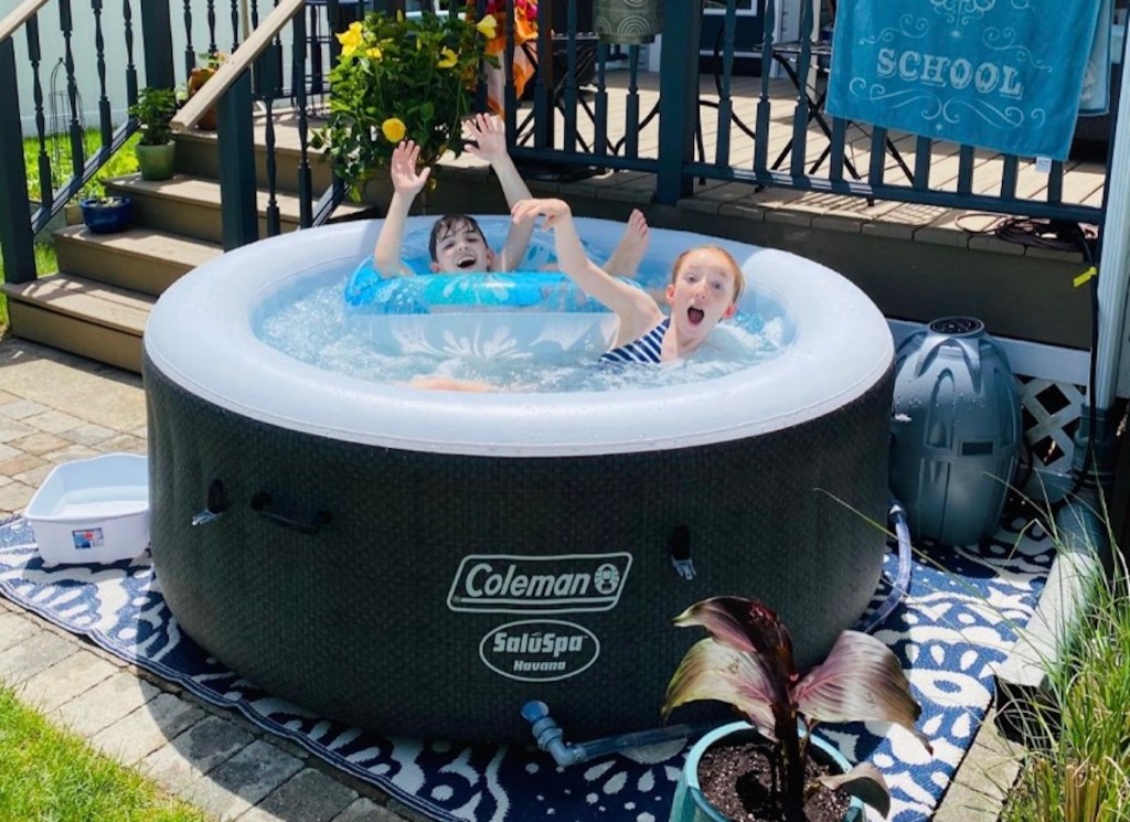 kids playing in coleman inflatable hot tub outside