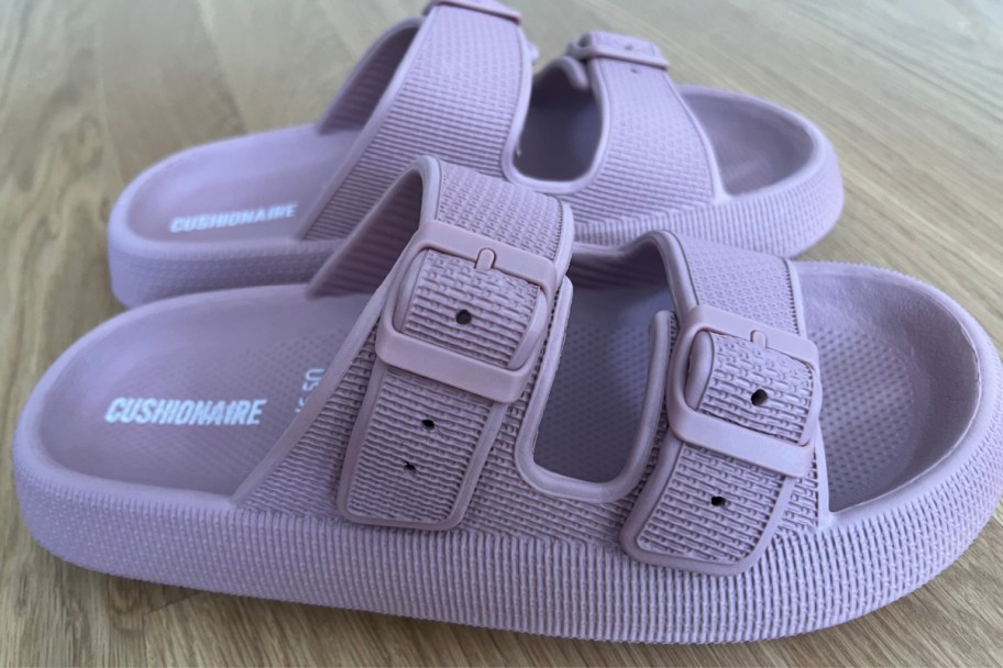 Close-up of purple slip on Cushionaire sandals shoes on wood floor