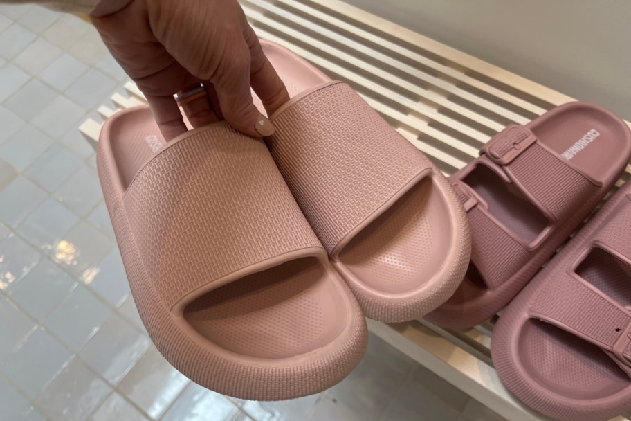 hand grabbing pair of pink cushionaire slides