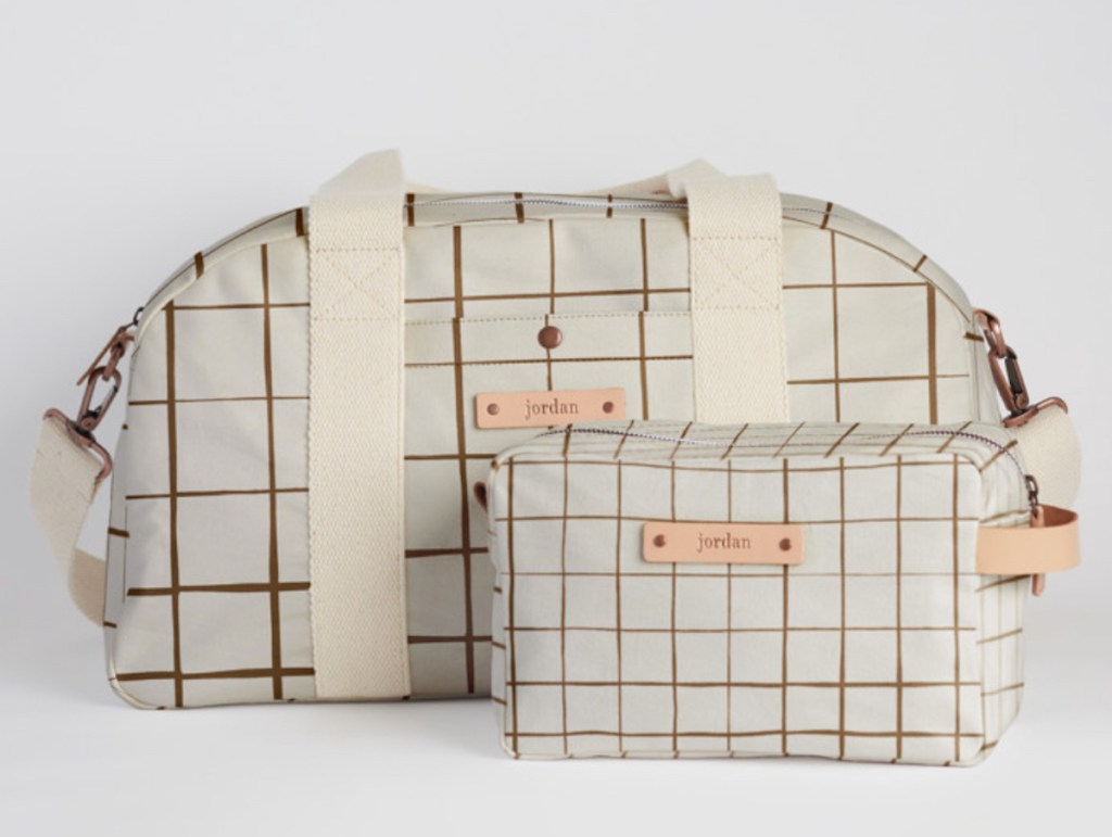 checked white and brown duffle bag and dopp kit toiletry bag on white background
