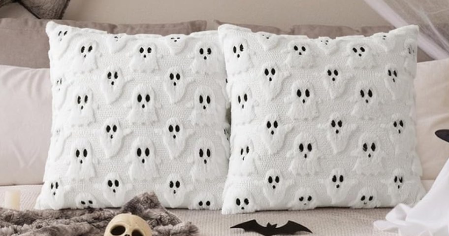 two white and black ghost themed throw pillows