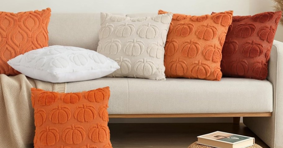 colorful pumpkin themed throw pillows on a couch