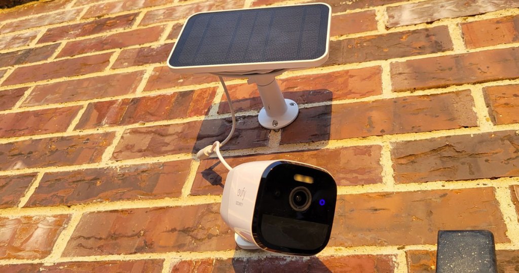security camera and solar panel on brick wall