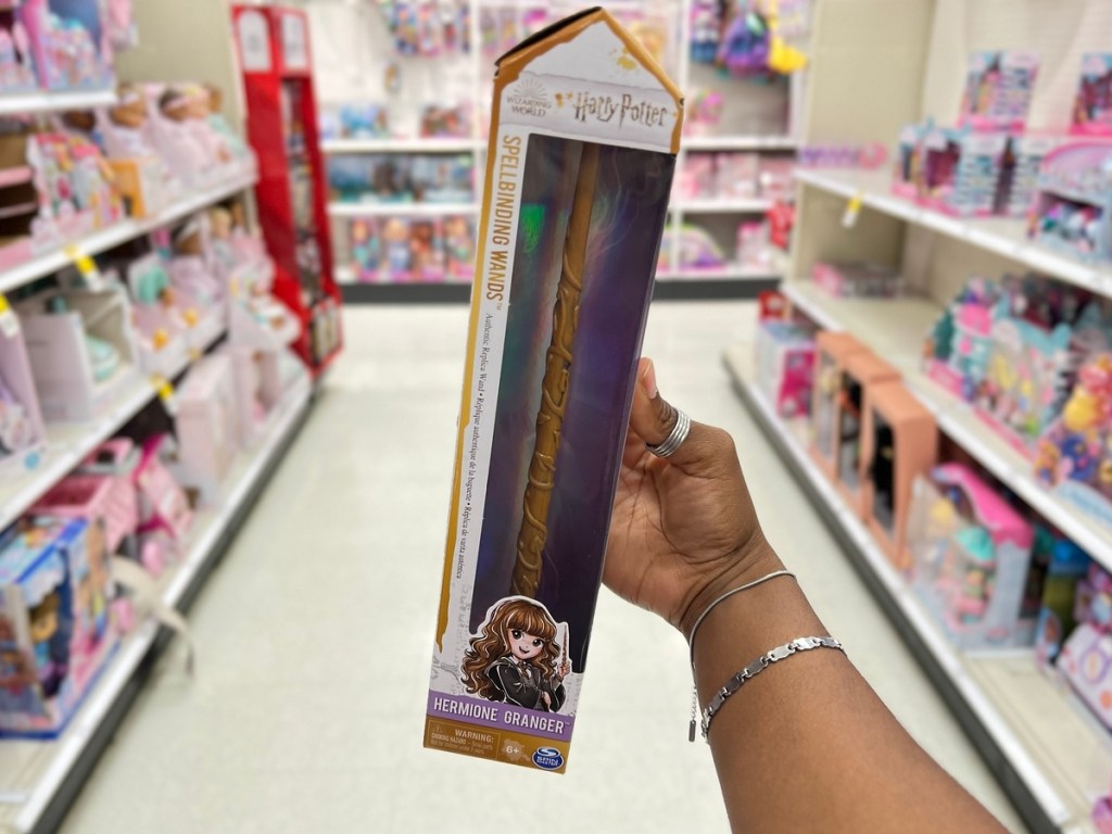 holding a Harry Potter talking toy wand 
