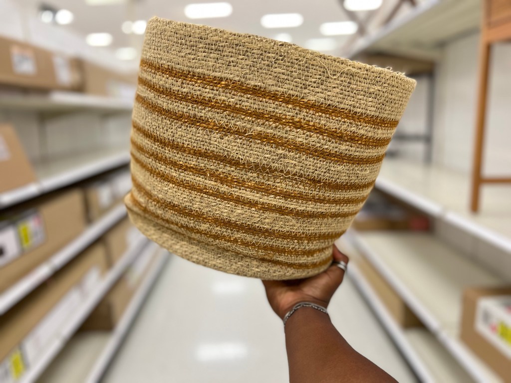 person holding round woven basket