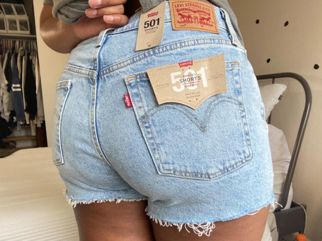 woman showing back of jeans shorts woth tags on
