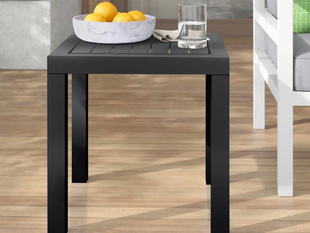 black side table with bowl of fruit