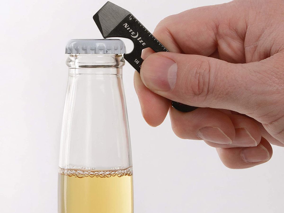 person using multitool to open bottle