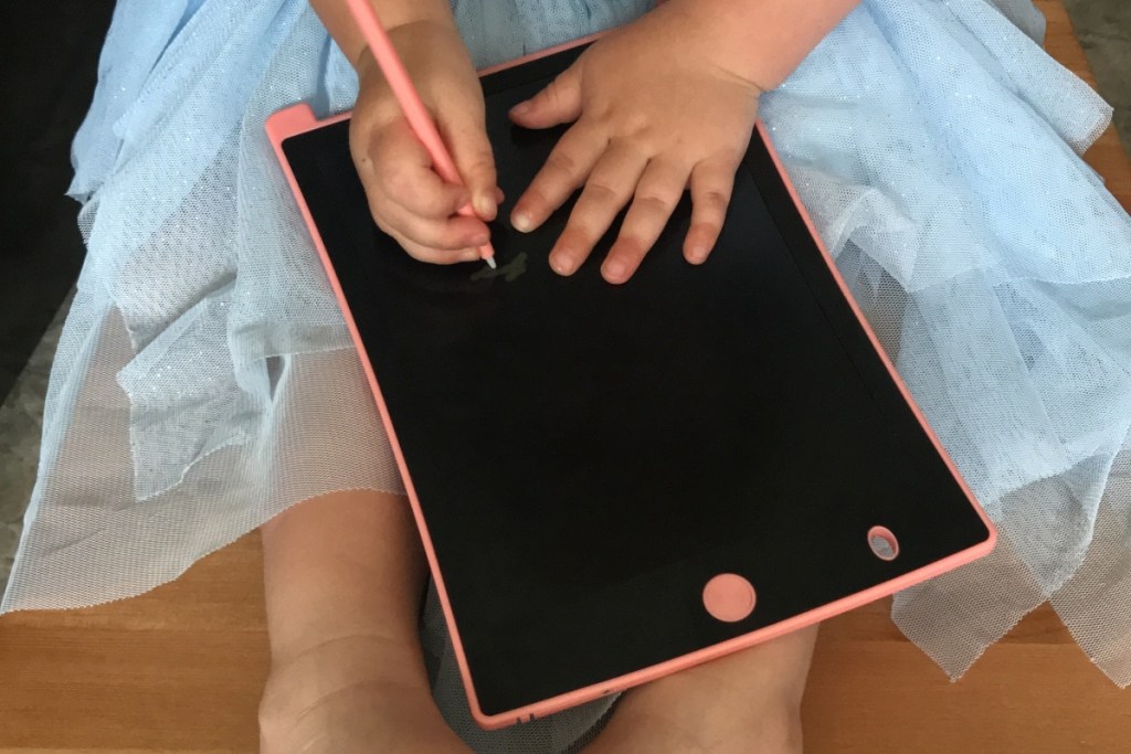 girl using doodle tablet on her lap