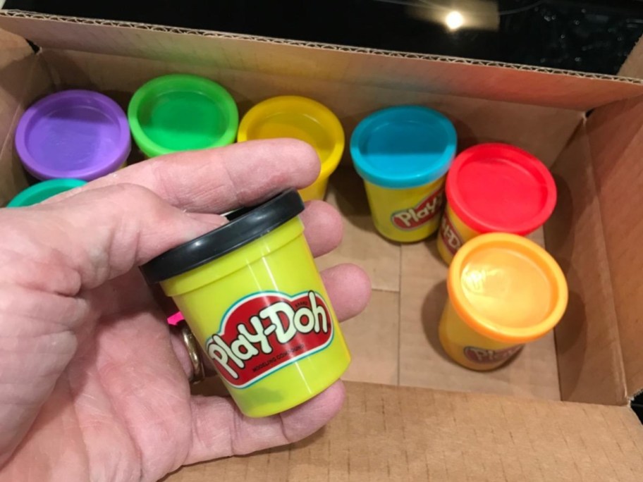 holding a small can of Play Doh