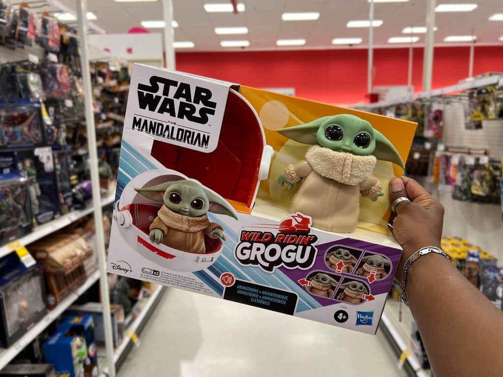 holding a Grogu toy in the box