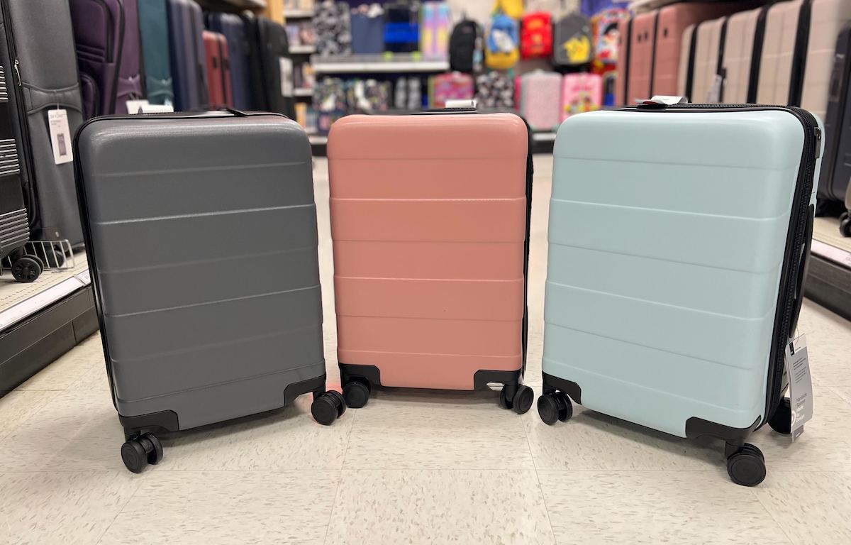 three luggage suitcases in a row on store aisle floor