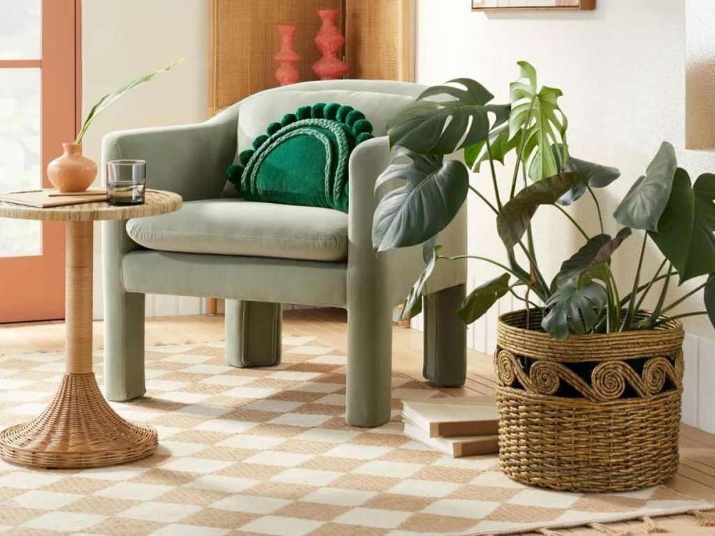 swirl woven basket holding plant sitting on area rug next to green chair