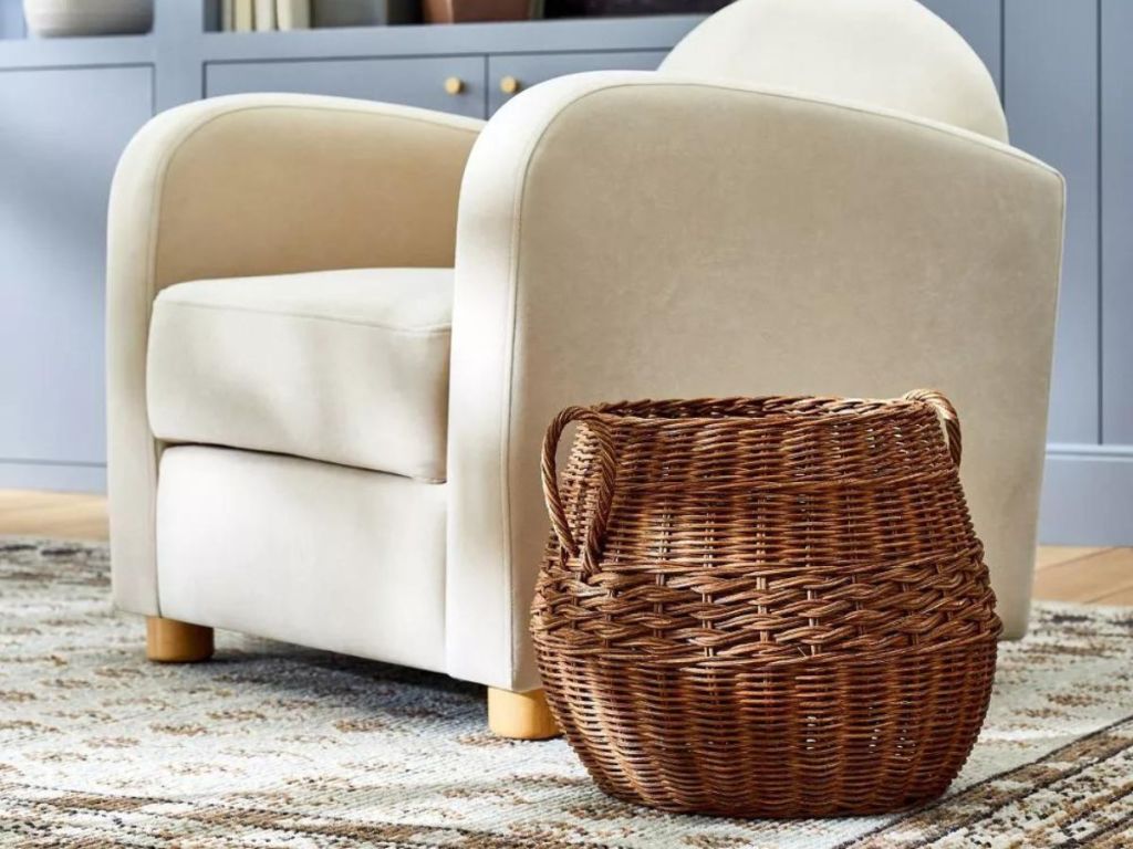 round rattan basket on living room area rug next to white chair