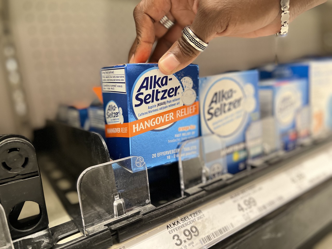 hand lifting a box of Alka Seltzer Hangover Relief off a target store shelf