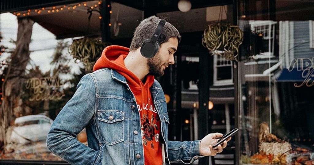 man wearing headphones and looking at his phone