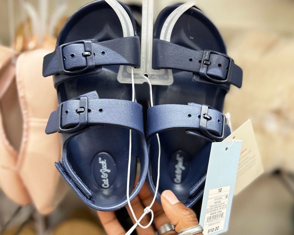 holding navy blue footbed sandals