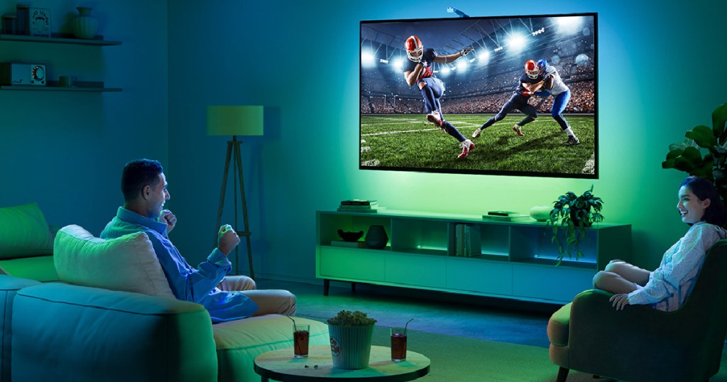 man and woman watching football game on tv with led backlights