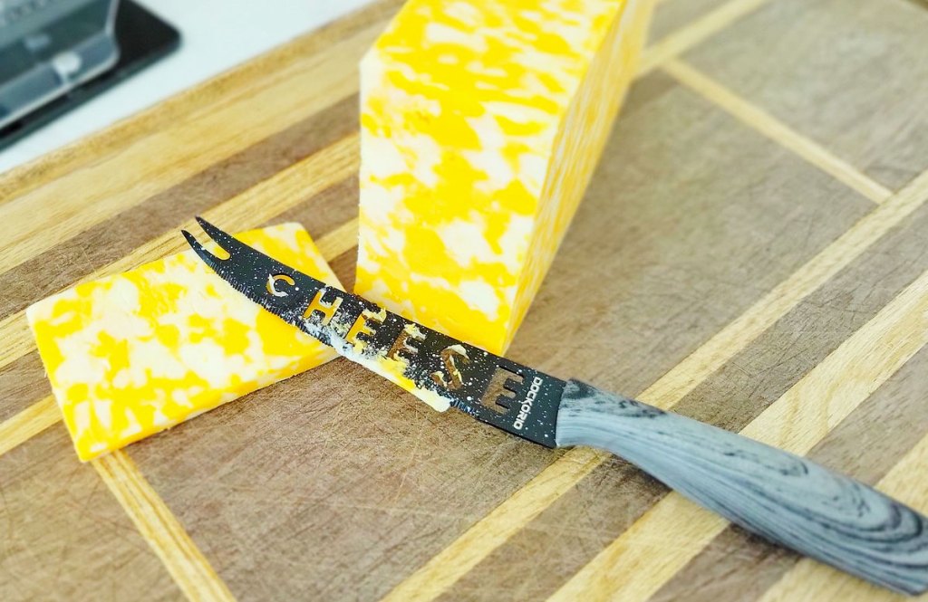 knife slicing into cheese block