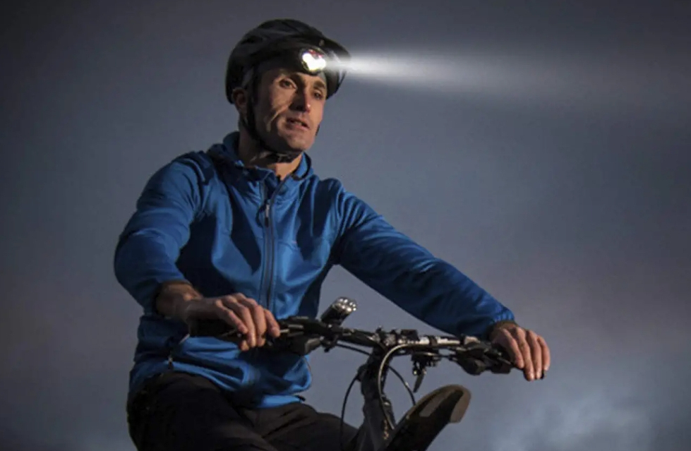 man wearing a headlamp while biking