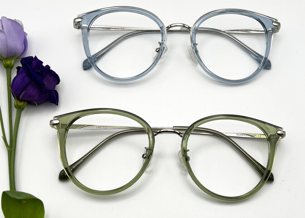 pairs of blue and green glasses next to purple flowers