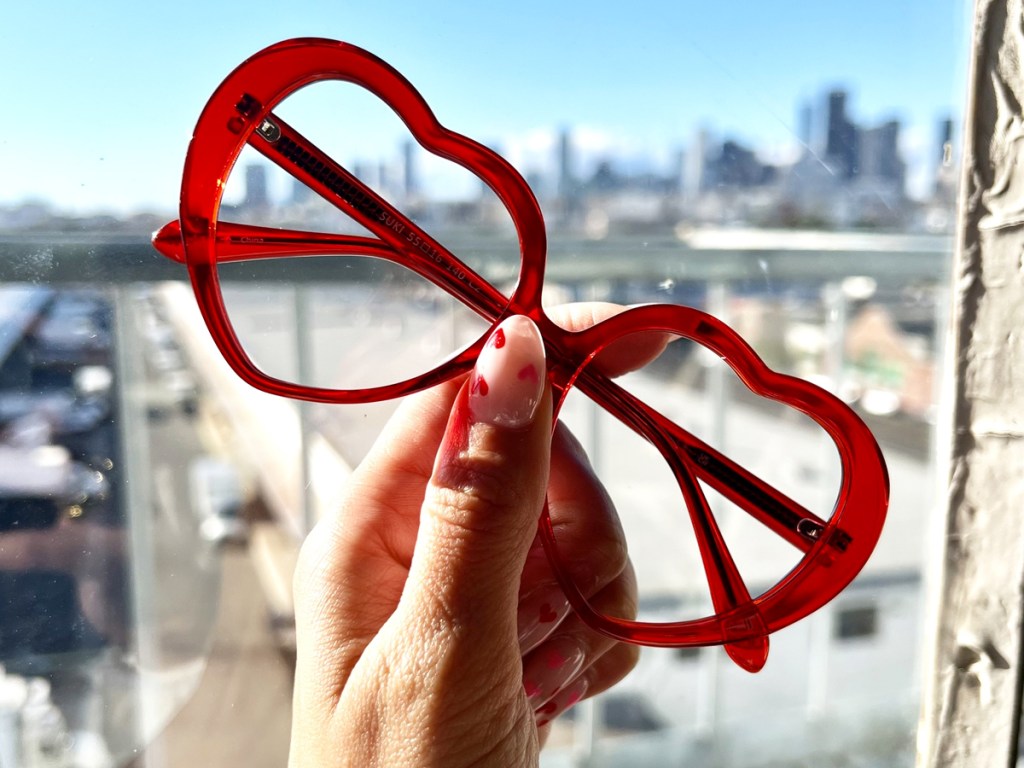 hand holding pair of heart shaped glasses