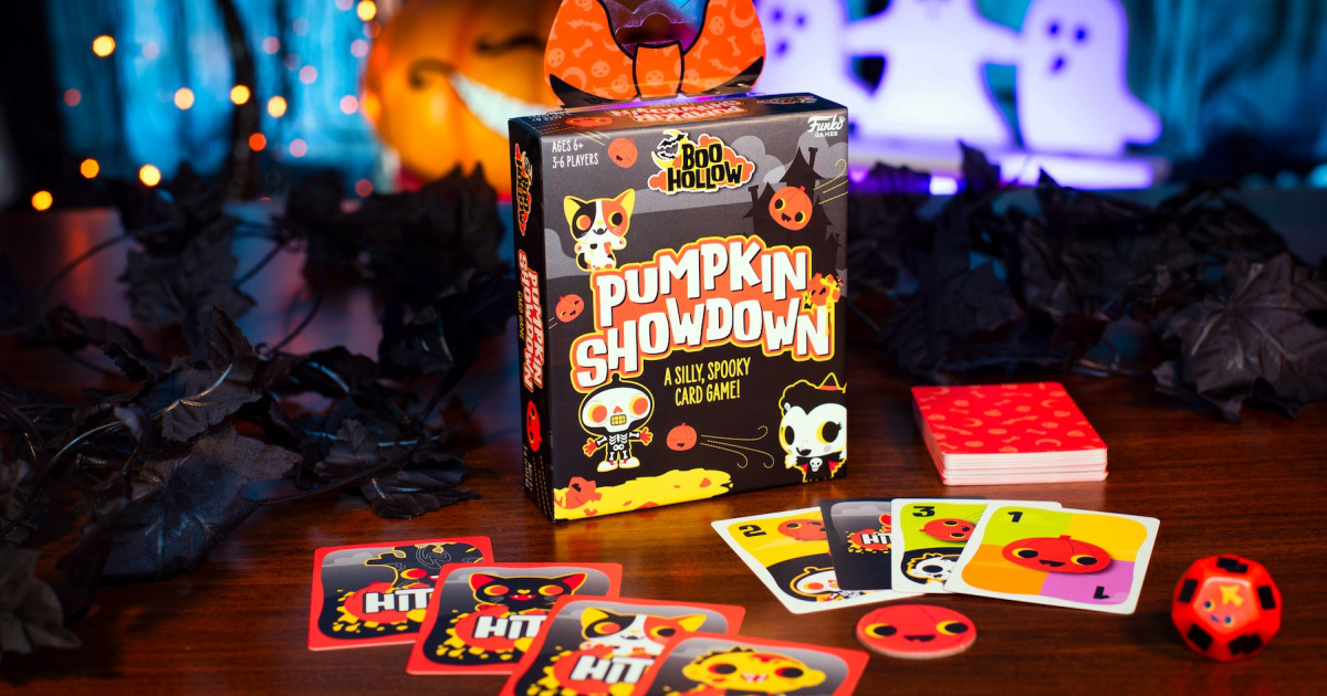 funko bool hollow pumpkin showdown card game and box displayed on a table surrounded by Halloween decorations