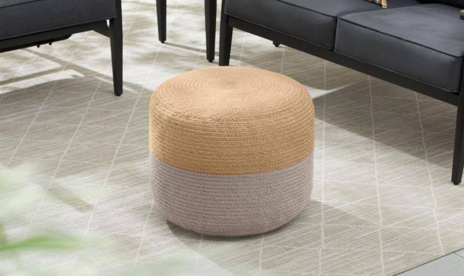 a natural and gray colored pet pouf ottoman on a patio