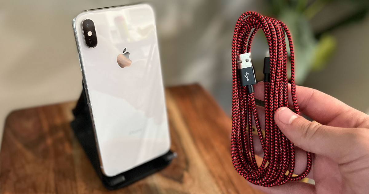 Hand holding charging cable next to iphone
