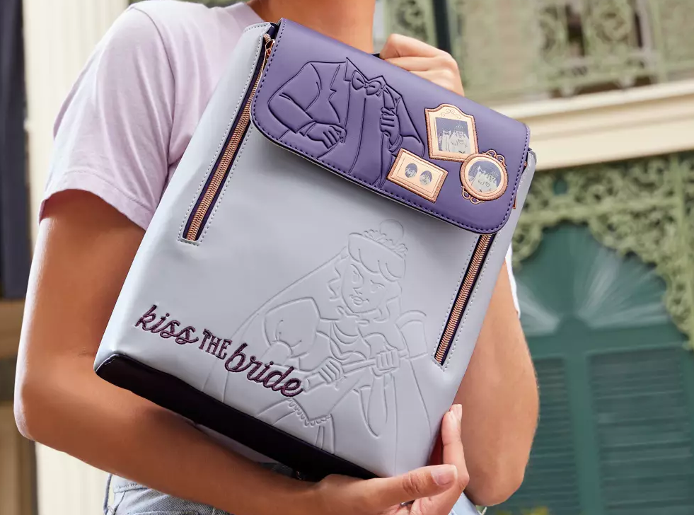 woman holding a Haunted Mansion Backpack