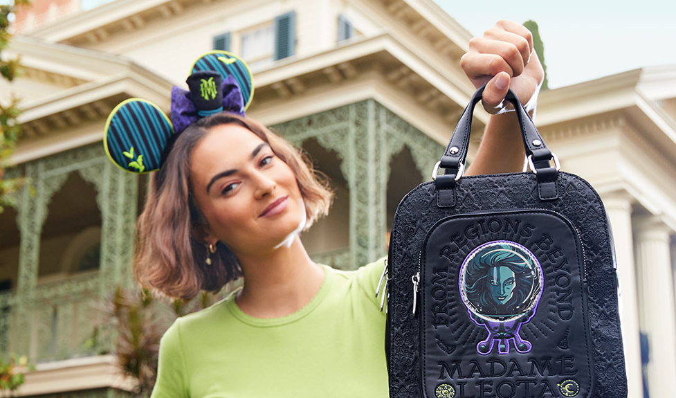 woman wearing Haunted Mansion ears and holding a backpack