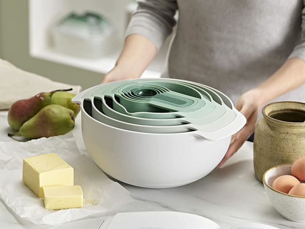 person setting nesting mixing bowls on a counter