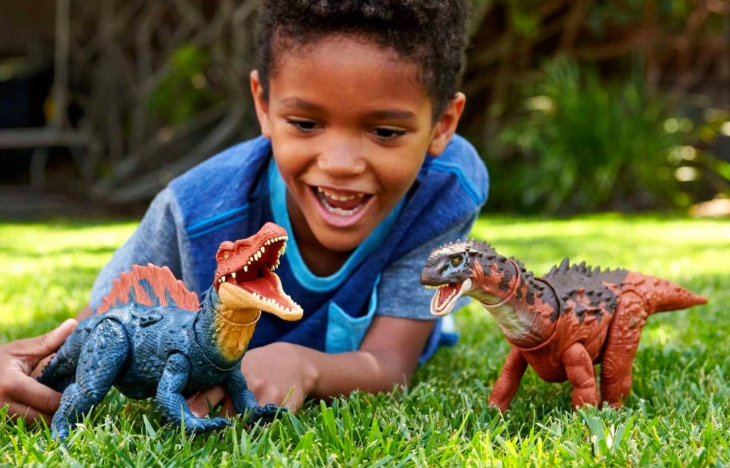 boy playing with dinosaur toys