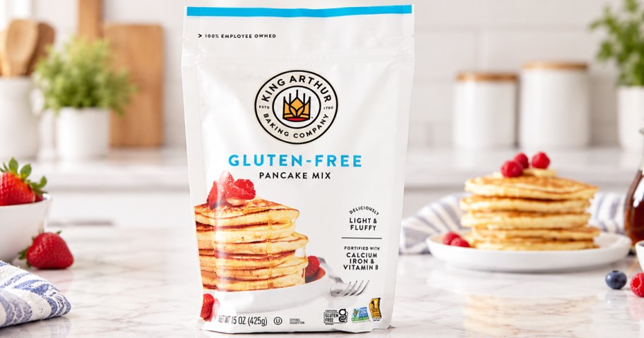 bag of King Arthur Gluten-Free Pancake Mix on counter with stack of pancakes in background
