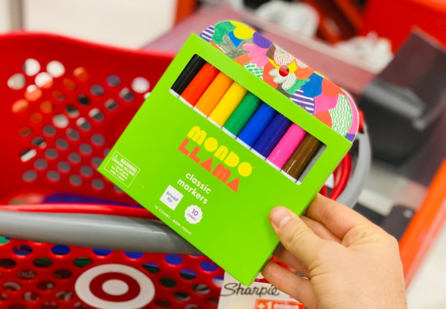 Hand pulling a pack of Mondo Llama markers from a Target basket.